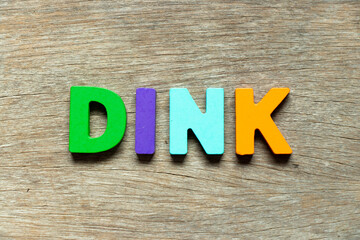 Color alphabet letter in word DINK (Abbreviation of Double income, no kids or Dual income, no kids) on wood background