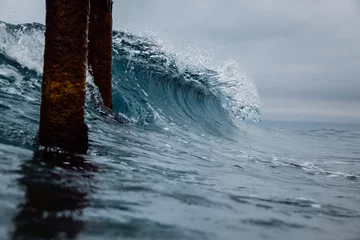Foto auf Leinwand Crashing glassy wave on the beach. Breaking ocean wave and pier © artifirsov