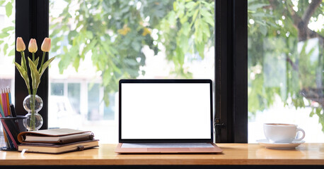 Laptop or notebook with blank screen on wood table in blurry background with house or office modern ,nature bokeh.