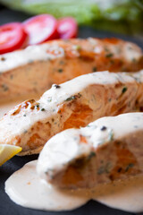 Cooked salmon fish with cream sauce in frying pan