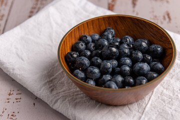 Superalimento orgánico antioxidante de arándanos, en un recipiente sobre una mesa de madera 