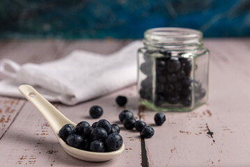 Superalimento orgánico antioxidante de arándanos, en un recipiente sobre una mesa de madera 
