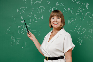 Teacher mature elderly lady woman 55 wear white shirt hold in hand demonstrate with pointer isolated on green wall chalk blackboard background studio. Education in high school September 1 concept.