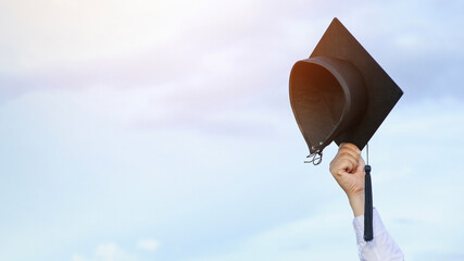Graduates are celebrating graduation put a hand up, a certificate, and a hat in hand with happiness...