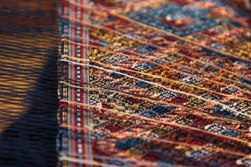 closeup of multicolor yarn of fabric weaving on loom, colorful abstract background