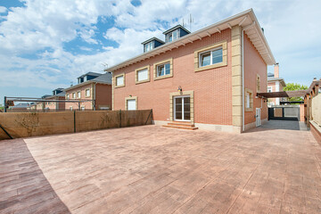 large patio tiled in wood ceramic simile of a single-family house on the outskirts of the city of...