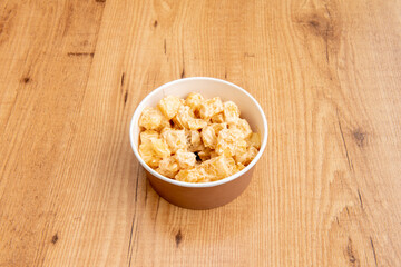 Home delivery cardboard bowl with chips with typical brava sauce from Madrid tapas bars