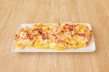 tray of delicious crisps with diced bacon and melted cheese on oak wood table