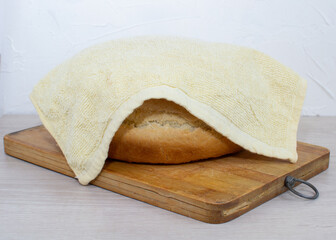 Homemade fresh bread on a wooden board close-up.