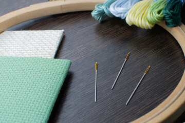 Materials for hand embroidery. Close-up of a gilded eye of a needle.
