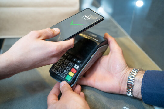 Contact less payment via smartphone. Conclusion of a money transaction through modern POS payment methods