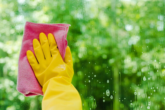 woman spraying and wiping glass