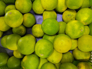 Fresh Green and yellow heap of Sweet limes kept in a shelf