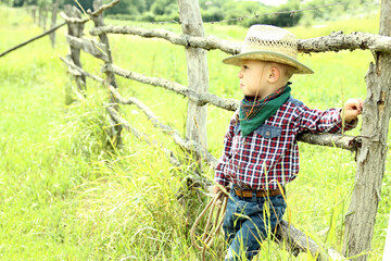 a little boy cowboy on nature