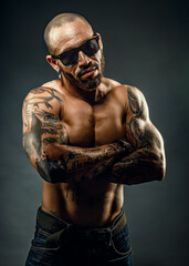 Studio portrait of a muscular African American or Latino with a naked torso. Male strength and...