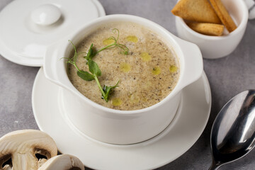 Mushroom cream soup in bowl with spoon on table
