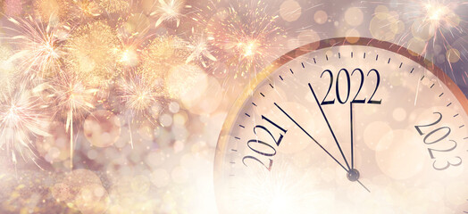 Clock counting last moments to New 2022 Year and beautiful fireworks on background, banner design