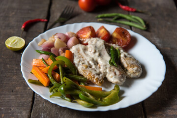 Continental dish chicken in white sauce in a white plate. Close up, selective focus.