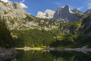 Gosau lake surrounded by Austrian Alps with Hoher Dachstein mountains view and reflections in summer sunny day