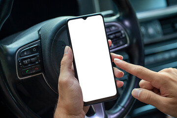 Close-up of young man holding mobile phone with blank screen in his hand he using navigator during driving. mockup phone