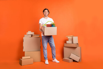 Full body photo of happy positive cheerful man hold hands move boxes delivery isolated on orange color background