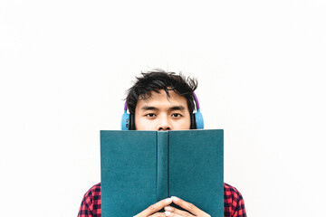 Asian young man reading a book or listening an audiobook outdoors - Asian social influencer having...