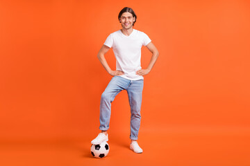 Fototapeta na wymiar Full body photo of cheerful young happy man football player good mood isolated on orange color background