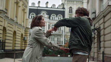 Lovely couple dancing on city background. Man and woman holding hands outdoor.