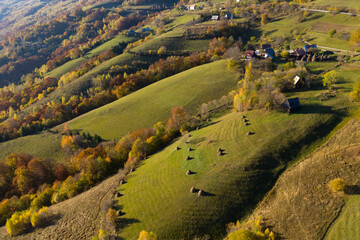 Aerial view of a small homestead and colorful autumn forest