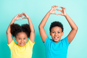 Portrait of attractive cheerful friends friendship showing heart sign isolated over bright teal...