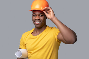 A dark-skinned construction engineer in a protective hemlet