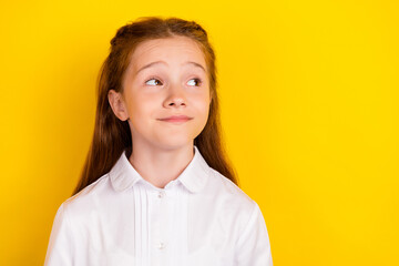 Photo of happy positive calm peaceful schoolgirl look copyspace thinking isolated on yellow color background