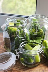 Cooking fresh pickled cucumber on a wooden table. Homemade pickles with dill and garlic in a jar. Canned cucumbers, pickled cucumbers