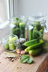 Cooking fresh pickled cucumber on a wooden table. Homemade pickles with dill and garlic in a jar....