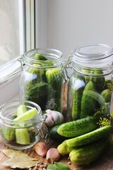 Cooking fresh pickled cucumber on a wooden table. Homemade pickles with dill and garlic in a jar. Canned cucumbers, pickled cucumbers