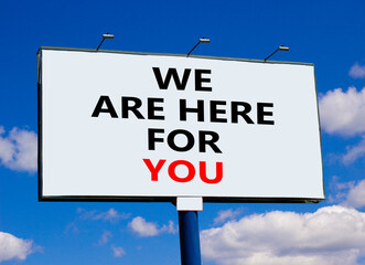 Support symbol. Words 'we are here for you' on white billboard. Beautiful blue sky. Business and support concept. Copy space.
