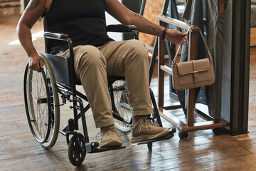 Obraz premium Cropped shot of woman in wheelchair holding handbag while getting ready to go out, copy space