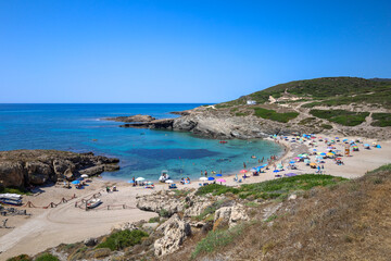 Fototapeta na wymiar Porto Palmas beach with tourists. Sassari, Sardinia, Italy, Europe