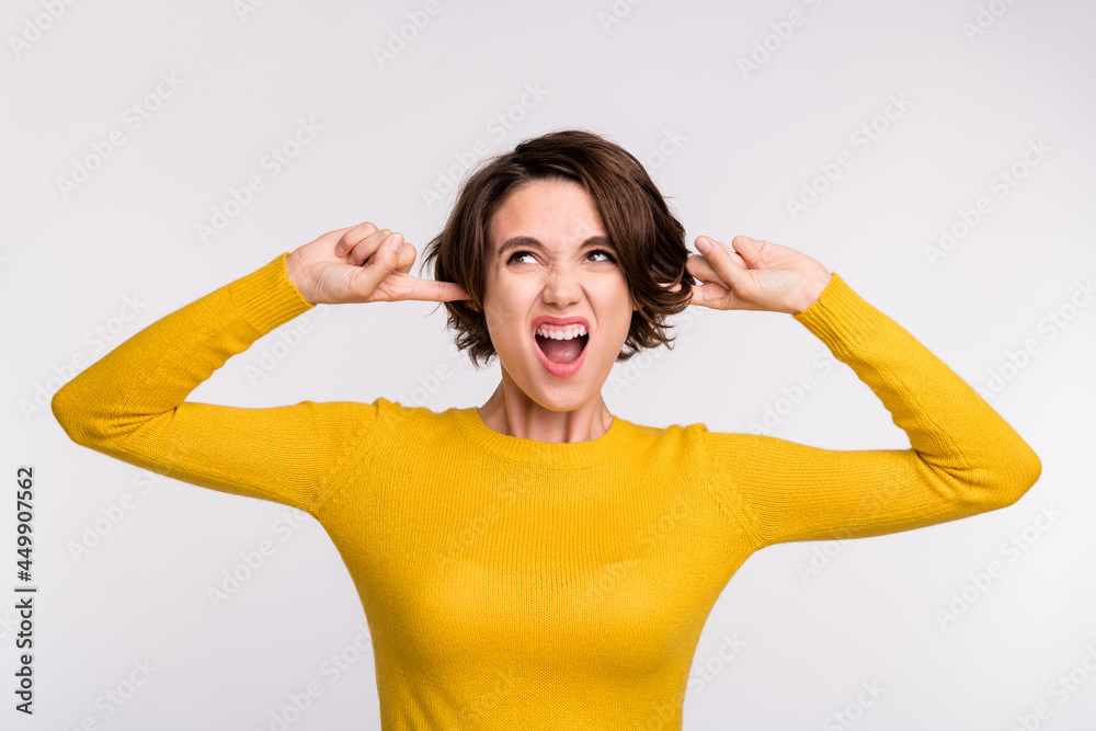 Poster Photo of young girl unhappy irritated annoyed cover ears yell loud noise isolated over grey color background