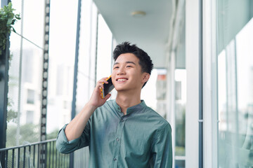 Handsome man having serious conversation on cell phone outside on balcony