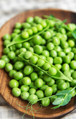 Fresh green peas pods and green peas with sprouts on textile background.