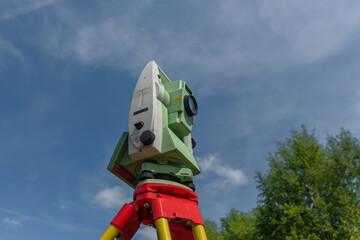 Machine for surveyors with blue sky and green trees in sunny day