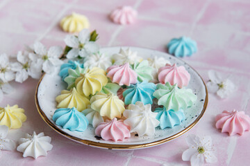 Fototapeta na wymiar Small colorful meringues in the ceramic plate