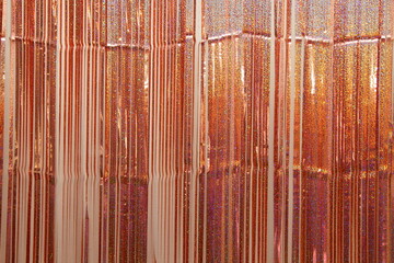 Shiny Golden colored tinsel vertical lines on the wall in horizontal picture, texture for a festive...