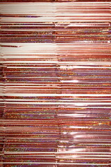 Shiny bronze colored tinsel horizontal lines on the table in vertical picture, texture for a...