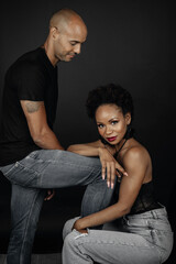 Latin couple posing on black background