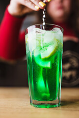 Professional cocktails with ice, lemon and alcohol - refreshing soft drinks from the bartender - the art of mixing liquids
