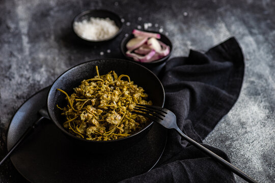 Bowl of traditional Georgian pickled jonjoli appetiser with red onion and salt