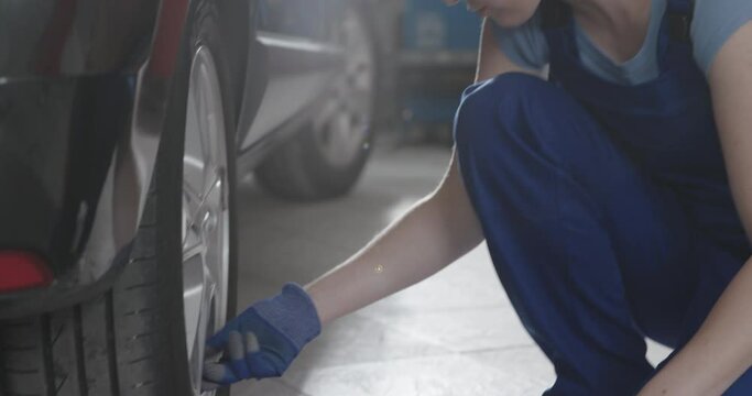 Female mechanic checking tire pressure