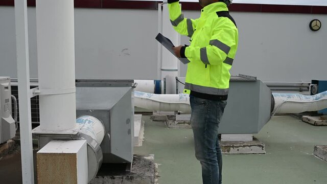 Air conditioning technicians repair and maintain condensing units outside the building, engineers inspect the operation of ventilation fans.